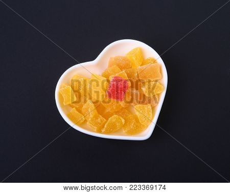 Delicious assorted dried organic fruit in bowl isolated on black background