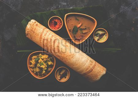 Masala dosa with chutney and sambar and potato sabzi. Cone, triangle or roll shape, selective focus