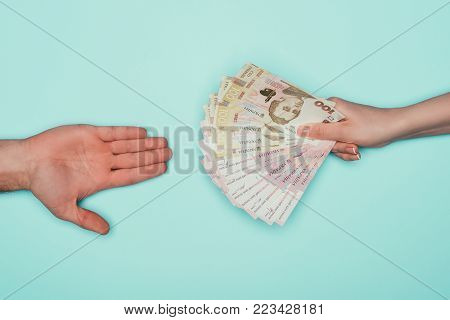 cropped shot of people passing cash isolated on turquoise