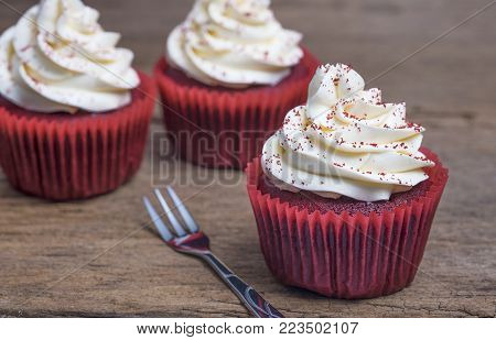 Red velvet cupcakes on wooden for celebration.