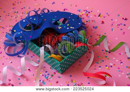 Praparing for carnival with blue mask and colorful paper ribbons.
