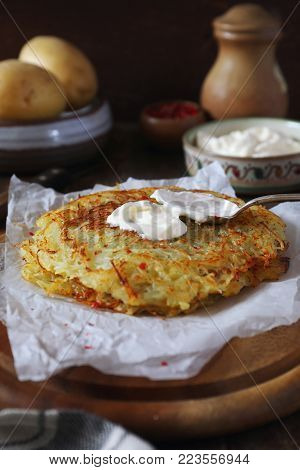 French cuisine. Pomme darphin: roasted pancakes from raw grated potatoes  with sour cream. Rustic style