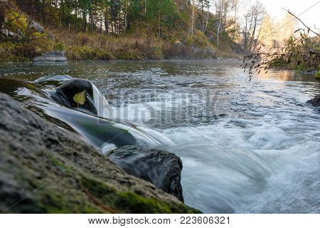 river in Russia, in the Urals, a quick course in the woods on a autumn background, outdoor