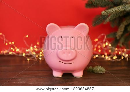 Piggy bank and blurred Christmas lights on background