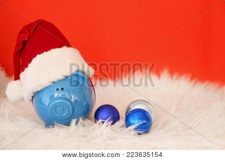 Piggy bank with Santa hat on faux fur