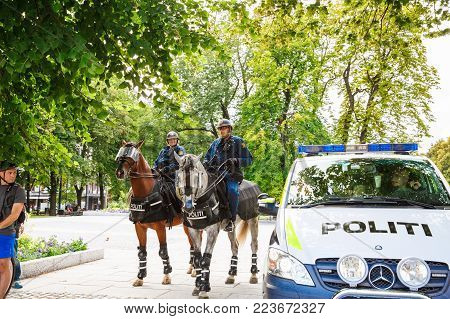 Oslo, Norway-August 13, 2014 -The  mounted police at the Norwegian parliament building and demonstration during a protest, Stortinget.