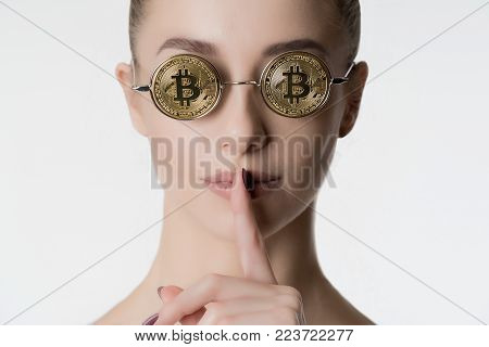 Young beautiful girl in glasses from bitcoin on white background