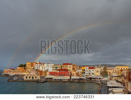 Scenic view of a rainbow after the rain of the Venetian waterfront of Chania. Mosque Hassan Kuchuk Pasha. Crete, Greece.