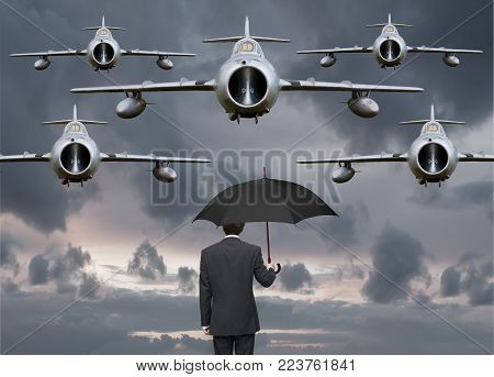 koncept businessman with an umbrella and military aircraft