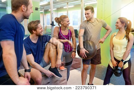 fitness, sport, exercising and healthy lifestyle concept - group of happy people with skipping rope, medicine ball and kettlebell in gym