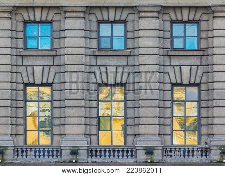 Several windows in a row on the facade of the urban historic building front view, Saint Petersburg, Russia