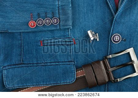 Elegant denim suit with a silver cufflinks and belt. Male jacket with cufflinks and pockets, close-up. Men's fashion. View from above.