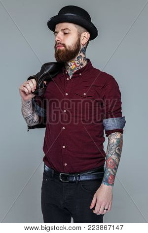 Male with tattoed hands and beard posing