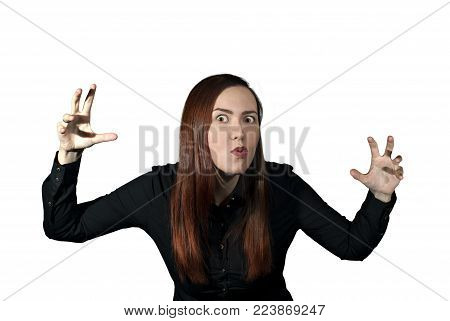 girl on a white background frightens the viewer, taking a menacing pose and making a terrible face
