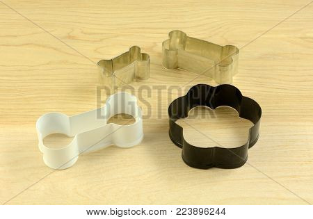 Dog themed cookie cutters in shapes of bones and of dog paw for making cookies for humans or treats for dogs