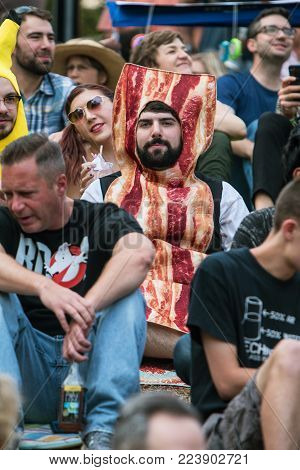 ATLANTA, GA - OCTOBER 2017:  A man wears a bacon costume as he sits among a crowd of spectators waiting for the start of the Little Five Points Halloween parade in Atlanta, GA on October 21, 2017.