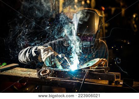 Welder working at the factory made metal, close-up.