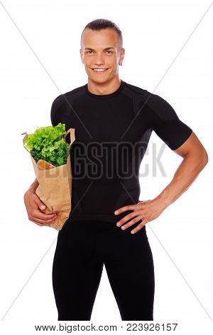Portrait of handsome man standing in store with food