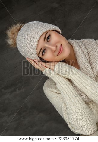 Awesome smiling woman in white pulover and winter hat.