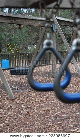 swing set outdoors with a tire swing and monkey bars for children to play on in neighborhood playground