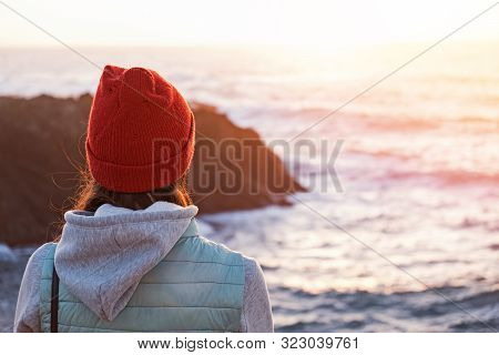 Woman In Red Hat Wathing Sunset Near The Ocean,