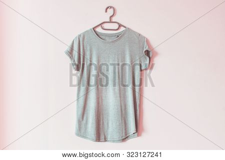 Old Not Ironed Folded Casual T Shirt Clothes Mockup Hanging On The Wall On A Rack.