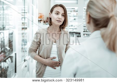 Attractive Woman Complaining To The Druggist Of Her Stomach Ache.