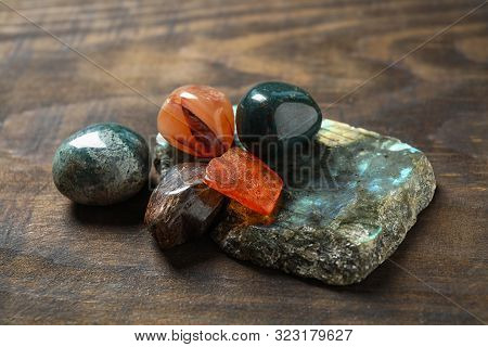 Different Beautiful Gemstones On Textured Wooden Table