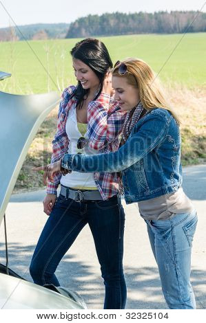 Le donne di ripartizione auto guardando sotto cappa tentano di riparare il motore