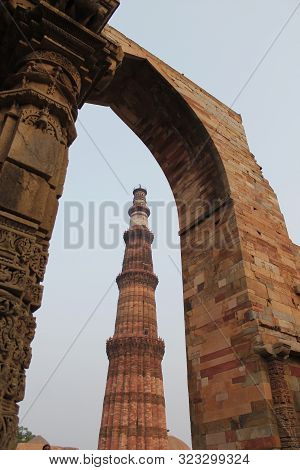 New Delhi, India - October 2014: Qutub minar, new delhi framed in a stone gate