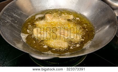 Close Up View Of The Frying Chicken In A Hot Boiling Oil In The Metal Wok.
