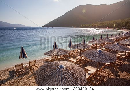 Summer Sunny Morning Sunbeds And Umbrellas Of Antisamos Beach On The Kefalonia Island, Ionian Sea, G