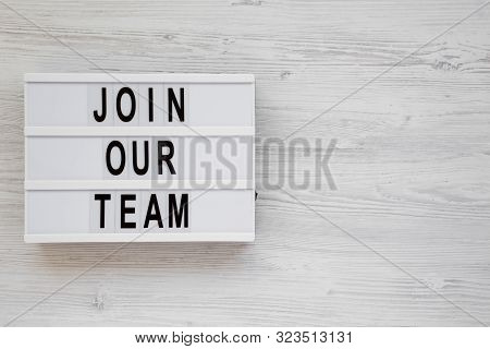 Top View, 'join Our Team' Words On A Lightbox On A White Wooden Surface. Overhead, From Above, Flat 