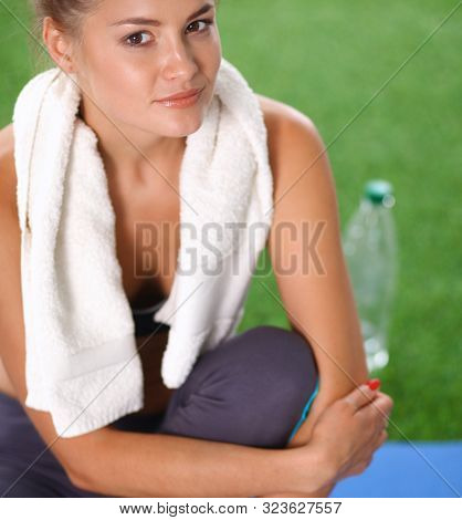 Beautiful young woman relaxing after exerscises on the grass