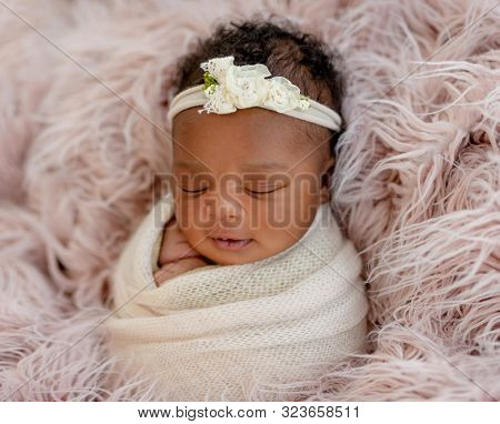 Sleeping African newborn baby girl with diadem