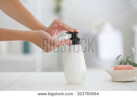 Woman With Bottle Of Soap In Bathroom