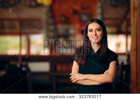 Manager Standing In A Restaurant Welcoming Customers