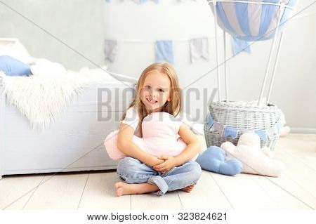 A Little Girl In Casual Clothes Holds A Cloud Pillow Against The Background Of A Decorative Balloon.