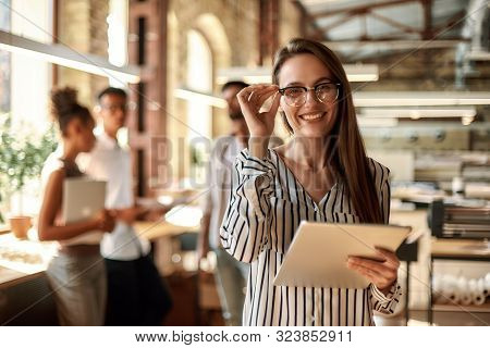 Successful Business Woman. Young Cheerful Woman Holding Digital Tablet And Looking At Camera With Sm