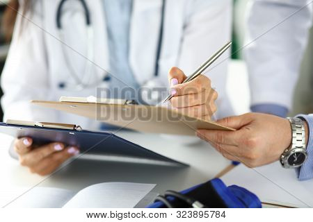 Two Gp Examining Test Results Clipped To Pad Closeu-up