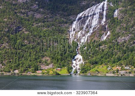 Norway Fiord Landscape - Part Of Hardanger Fjord Called Sorfjord. Waterfall Falling Into The Fiord.