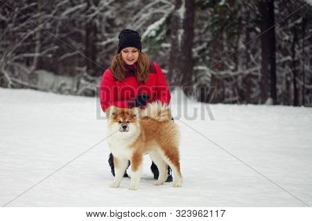 Portrait With A Cute Fluffy Puppy. Winter Walk With A Dog. Young Woman Walks With The Puppy, Snowy W