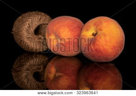 Group Of Two Whole Fresh Fuzzy Peach With Spool Isolated On Black Glass