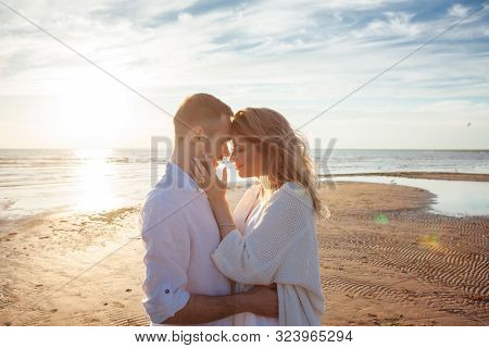 Love, Romance, Walk. Portrait Of A Beautiful Couple In White Kissing On The Background Of The Sunset