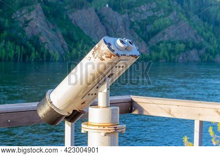Free Tourist Metallic Binocular Against Natural Background. Telescope For Sightseeing On The Embankm