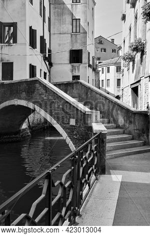 Venice in Italy. Canal with small bridge. Black and white photography, venetian view