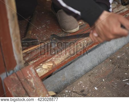 Worker Hands With Prybar Removing Old Doorstep, Outdoor Closeup