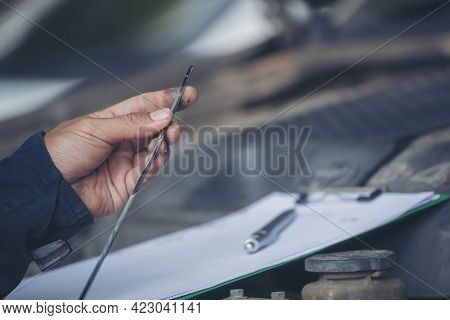 Car Mechanic Man Hand Checking Dipstick Engine Oil Car Mechanical On Site Service. Close Up Hand Man