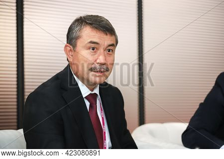Minsk. Belarus - 05.31.2021 - A Gray-haired Man In A White Shirt And Red Tie At The Tibo Exhibition 