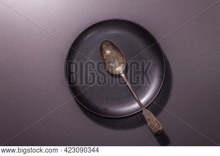Dark Ceramic Plate And Vintage Spoon As A Table Settings Style